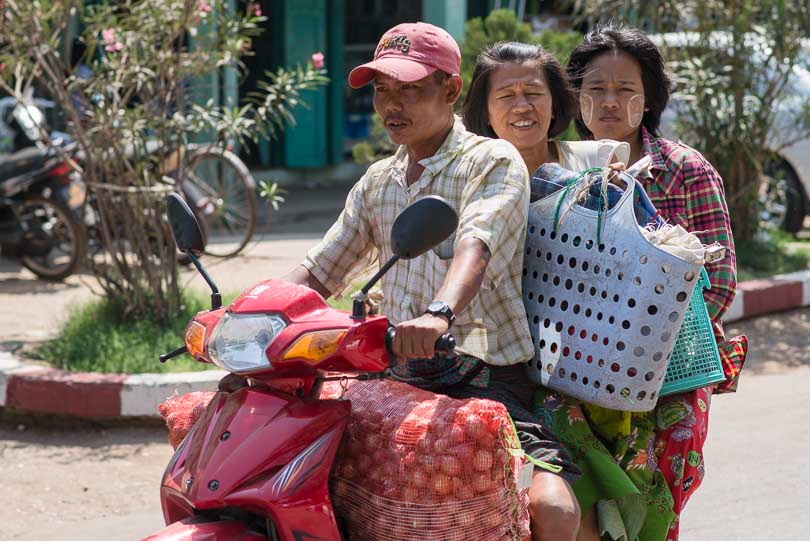 Menschen mit ihrem Grßeinkauf auf einem Moped in Myanmar